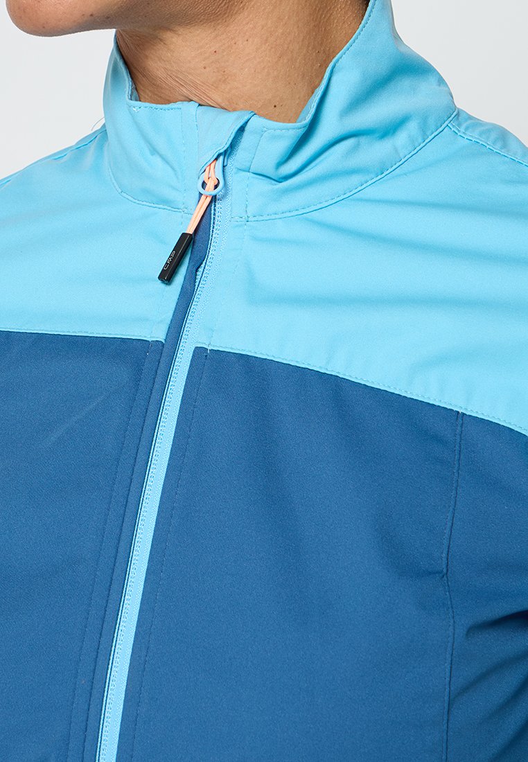 Giacca leggera con zip, caratterizzata da un design bicolore, con la parte superiore blu cielo e la parte inferiore blu scuro. Tessuto morbido con colletto alto.