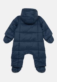 Combinaison de neige rembourrée bleue avec capuche, présentant un design matelassé, des poignets élastiques et des jambes avec pieds. Texture lisse avec un style simple et pratique.