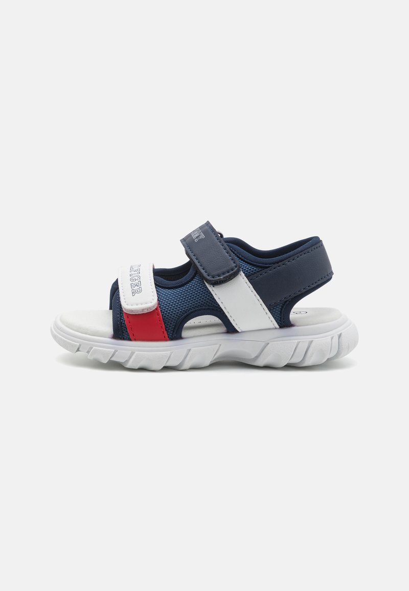 Navy and white sandal with red accents, featuring mesh panels, adjustable Velcro straps, and a textured sole for grip.