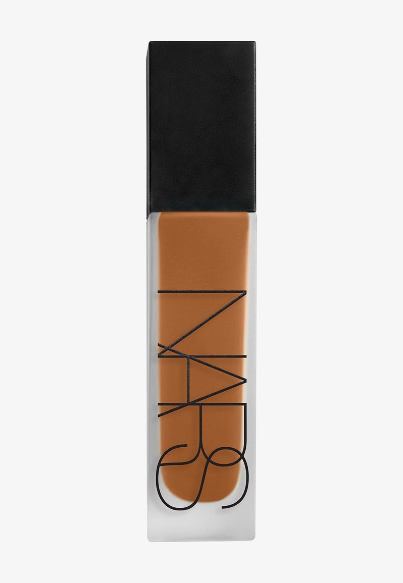 Bouteille rectangulaire en verre dépoli contenant un fond de teint liquide marron moyen avec un capuchon carré noir mat, logo de la marque NARS vertical sur la bouteille.