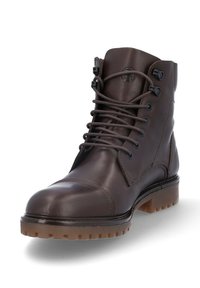 Bota de cuero marrón con punta redonda, parte delantera con cordones y ojales de metal. Presenta una suela texturizada y acentos de costura en los laterales.