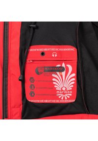 Sarkanais mētelis ar melnu sietu iekšpusē un kabatu ar rāvējslēdzēju. Ietver zīmola un ūdensizturīgus uzlīmes baltā krāsā.