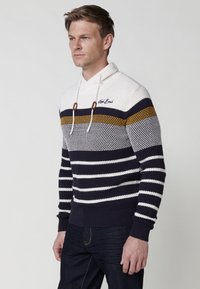 Suéter de punto con rayas en navy, blanco y mostaza; capucha con cuerda ajustable y acentos en marrón; tela texturizada; puños de canalé.