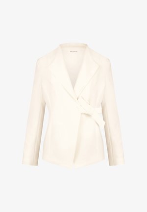 White tailored blazer with a shawl collar, wrap front, and side tie. Made of smooth fabric, featuring long sleeves and structured shape.