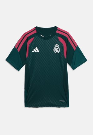 Maillot de football vert foncé du Real Madrid avec des rayures roses, logo Adidas sur la poitrine droite et écusson du club sur la poitrine gauche.