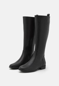Sorte knæhøje støvler lavet af glat syntetisk materiale. Rund tå, lav begremmet hæl og minimal syningdetaljering. Elegant og alsidig design.