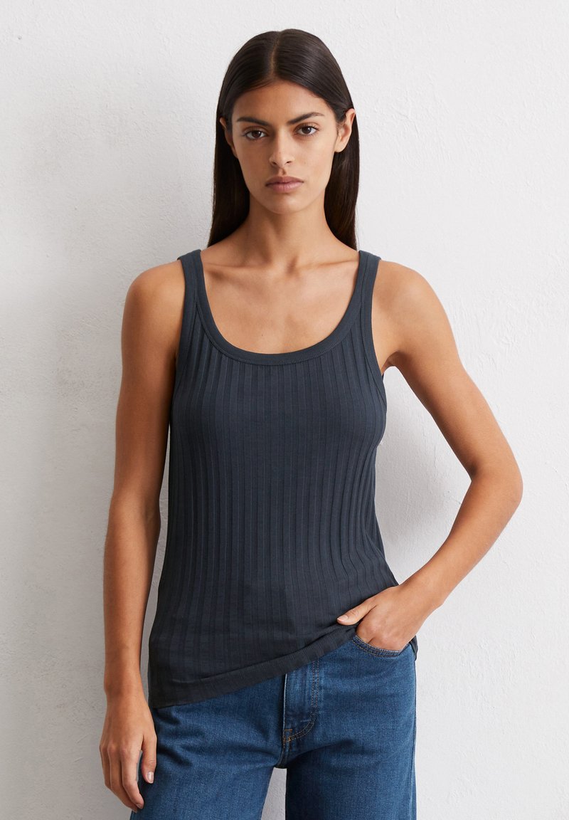 Ciemnoszary prążkowany top na ramiączkach z szerokimi paskami i zaokrąglonym dekoltem. Materiał wydaje się miękki z lekką teksturą, część codziennego stylu w połączeniu z dżinsami.