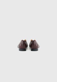 Bordeauxfärgade läderskor med en slät yta, rund tå och minimalistisk design. Platta svarta sulor och ingen synlig hårdvara.