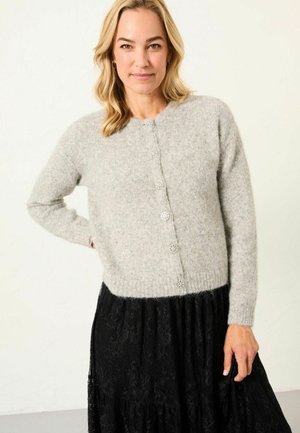 Hellgrauer Wollcardigan mit langen Ärmeln und rundem Ausschnitt, ausgestattet mit fünf dekorativen Knöpfen und einem gerippten Saum. Kombiniert mit einem schwarzen Spitzenrock.