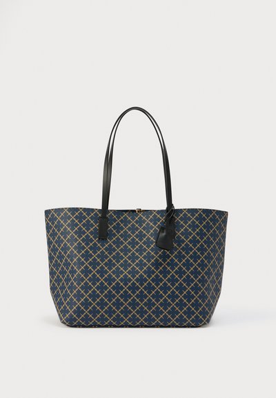 Grand sac cabas bleu marine, présentant un motif géométrique doré. Texture lisse avec des poignées et des accents en cuir noir.