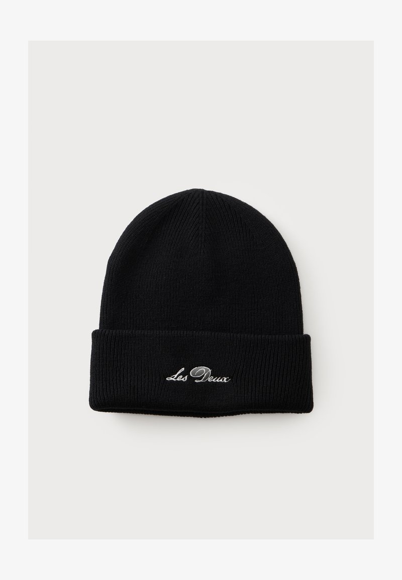 Bonnet en tricot noir avec revers plié présentant un texte brodé blanc "Les Deux" sur un fond clair uni.