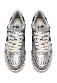Le sneakers metallici argento presentano una punta perforata, dettagli neri sui lati e lacci bianchi. L'interno è chiaro e imbottito.