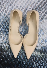 Béžové lakované baleríny s špičatou špičkou a otevřenými stranami, s podšívkou s hadím vzorem a hladkým povrchem.