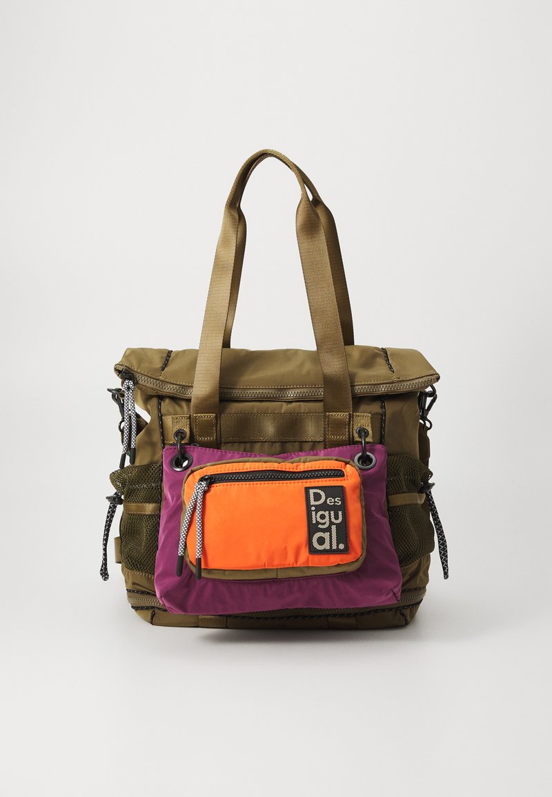 Bolsa tote de color verde oliva con parte superior plegable, bolsillo frontal púrpura y naranja, dos asas de lona y bolsillo lateral de malla. Cuenta con cremalleras y branding.