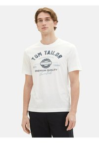 Balta kokvilnas T-kreklu ar tumši zilu grafiku, kurā ir teksts "Tom Tailor" un "Premium Quality"; īsas piedurknes, apļa kakla dizains.