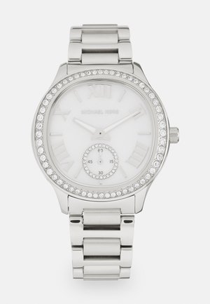 Zilveren roestvrijstalen horloge met een witte wijzerplaat, Romeinse cijfers en een bezel met rhinestones. Bevat een kleine subwijzerplaat aan de onderkant.