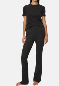 Black short-sleeve t-shirt and flared pants made of soft fabric. Simple design with a round neckline and a comfortable fit. No patterns or accents.
