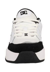 Vit sneaker med svarta accenter, texturerat läder och mocka material, med framträdande snören, vadderad krage och en logotyp på plösen.