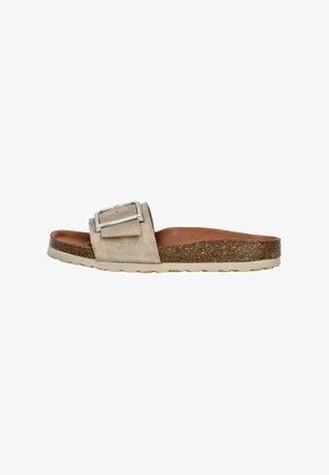Sandale à glissière en daim beige clair avec une boucle en argent. Semelle en liège et semelle en caoutchouc blanc. Design plat, forme minimaliste et confortable.