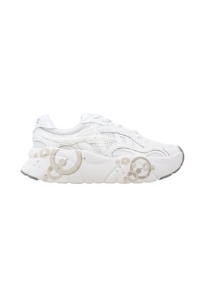 Sneaker sportiva bianca con suola spessa decorata con motivi a bolle beige chiaro, tomaia in mesh e pelle, vista laterale.