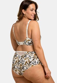 Ensemble de bralette et culotte taille haute à motif floral blanc, avec des accents noirs et dorés ; bretelles ajustables et dentelle sur la culotte.