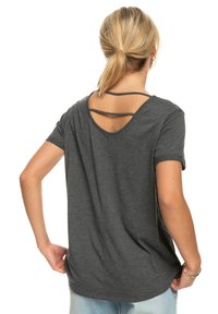 Gray short-sleeve t-shirt with a relaxed fit, featuring a scoop back with double strap detail. Soft fabric with a smooth texture.