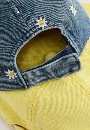 Șapcă din denim cu umbra galbenă, detalii de broderie florală și curea ajustabilă în partea din spate. Prezintă o formă rotundă și structurată.