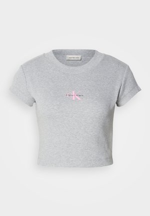 Pilkas trumpas medvilninis marškinėliai, su gilia cebūne ir trumpomis rankovėmis. Priekyje puikuojasi rožinė Calvin Klein logotipas.