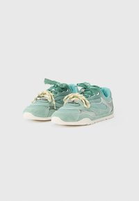 Αθλητικά παπούτσια σε μέντα πράσινο χρώμα, κατασκευασμένα από σούεντ και πλέγμα, με επενδεδυμένο γιακά, υφασμένα κορδόνια και λευκή ελαστική σόλα με διακριτική λεπτομέρεια λογότυπου.