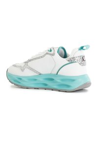 Baskets blanches avec semelle aqua et accents argentés. Présente un dessus texturé et une silhouette arrondie. Lacets et tirette à l'arrière.