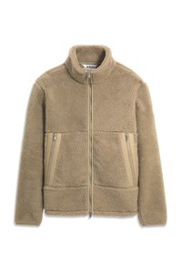 Veste polaire beige avec fermeture éclair intégrale, col montant et deux poches verticales zippées à l'avant, en tissu doux texturé.