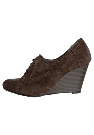 Brune ruskinds kilehæle med rund tå, snørebånd foran og detaljeret syning over det øverste, som har en tekstureret kile.