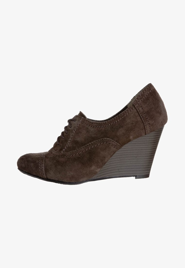 Chaussure à talon compensé en suède marron avec un bout rond, un laçage à l'avant et une couture détaillée sur le dessus, présentant un talon texturé.