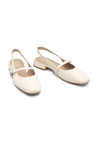 Beiga slingback-skor med fyrkantig tå, platt klack och justerbart ankelband. Slät lädertextur och minimalistisk design.