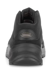 Zwarte sportieve schoen met een gestructureerde bovenkant, gevoerde kraag en een reflecterend logo. Dikke rubberen zool met een profiel voor grip.