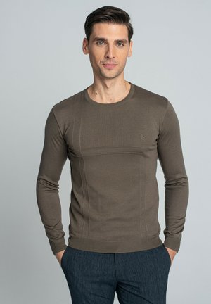 Brązowy sweter dzianinowy z długim rękawem o dopasowanym kroju i prążkowanej fakturze. Posiada subtelne detale w szwach oraz małe logo na piersi.