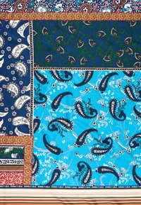 Tela de patchwork colorido con patrones de cachemira y flores en tonos azul marino, verde y azul, con bordes de diseños ornamentales y rayas.