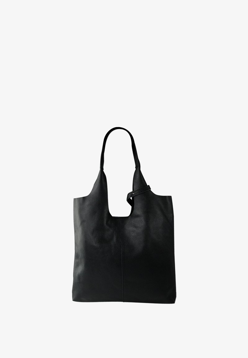 Sac tote en cuir noir avec une finition texturée, ouverture en haut, et doubles bretelles. Présente un détail découpé unique en haut.