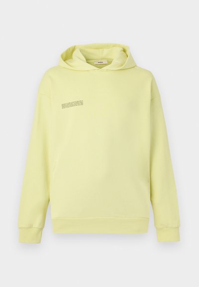 Φούτερ με κουκούλα σε ανοιχτό κίτρινο χρώμα με μακριά μανίκια και μικρό μαύρο κείμενο στην αριστερή πάνω πλευρά του στήθους, παρουσιάζεται πάνω σε απλό φόντο.