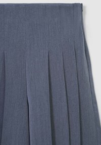 Gonna pieghettata grigio scuro con vita e cerniera laterale, realizzata in tessuto testurizzato, appesa su uno sfondo bianco.