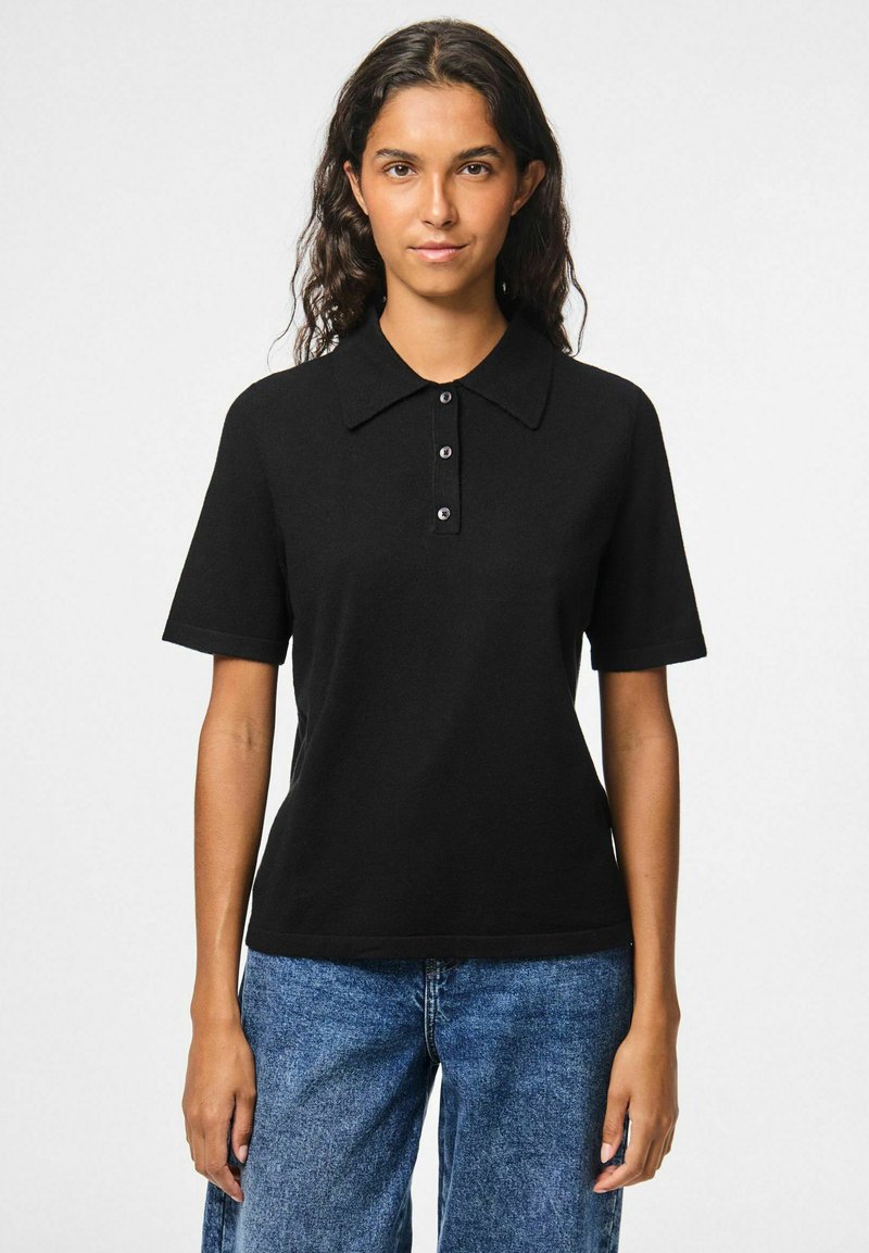 Black polo shirt with short sleeves, featuring a classic collar and three-button placket. Smooth texture and simple design.