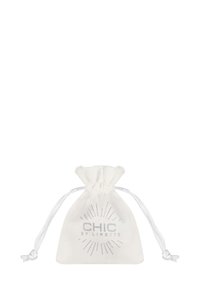 Pochette à cordon en tissu blanc. Dotée d'un logo argenté avec un motif d'éclat et de deux cordons blancs pour la fermeture. Forme compacte.