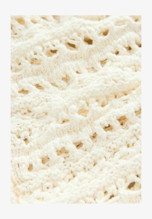 Tissu tricoté blanc avec un motif ajouré, présentant des boucles et des points texturés, créant une apparence délicate et aérienne.