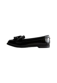 Zwarte gepatineerde leren loafers met een lage hak, voorzien van een decoratieve strik op de neus en een gestructureerde zool voor grip.