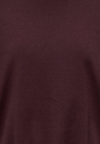 Pull en tricot bordeaux avec une texture douce, comprenant des détails côtelés et une coupe décontractée, idéal pour superposer ou porter au quotidien.