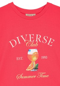 Różowa bawełniana koszulka z grafiką przedstawiającą kieliszek koktajlowy z plasterkiem pomarańczy oraz napisem "Diverse Club Summer Time."