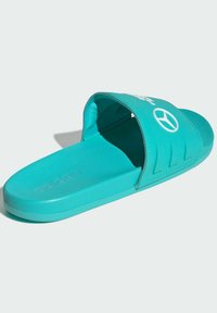 Turkisfarvet slidesandal med en bred rem, der har et logo, tekstureret fodseng og et rent, buet silhuet. Fremstillet af holdbart syntetisk materiale.