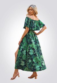 Vestido maxi con escote off-the-shoulder y un estampado de hojas verdes sobre un fondo azul marino, que cuenta con una cintura ajustada y una abertura lateral, fabricado en un tejido ligero.