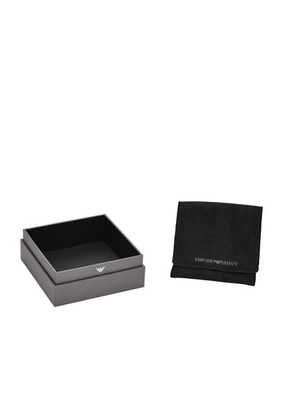 Grå pappkartong med matt yta, med en silverfärgad logotyp på toppen, tillsammans med en svart mockapåse med präglad märkning.