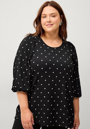 Zwarte blouse met witte stippen, gestructureerde stof, ronde halslijn en bellende mouwen die bij de manchetten zijn verzameld.